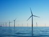 China Clean Energy Capacity Surpasses Fossil Fuels Solar panels and wind turbines stretch across a Chinese landscape under a clear blue sky.
